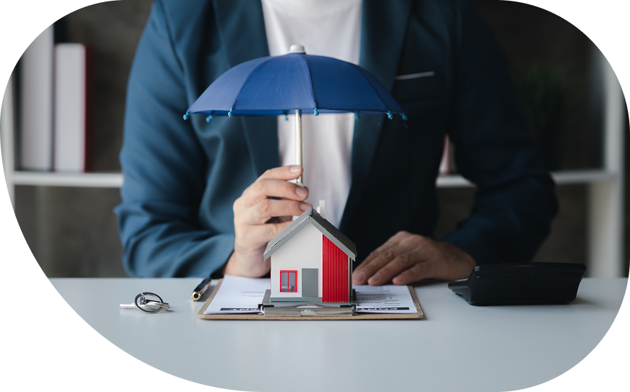Insurance agent holding an umbrella over a model home